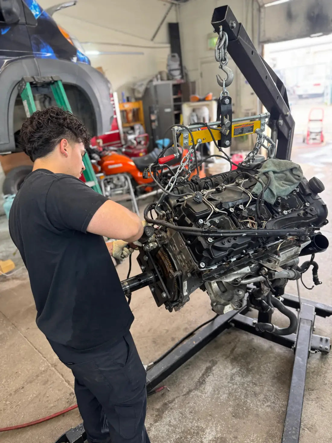AYRD technician repairing an engine on a hoist
